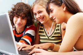 Three young people are looking at a computer.