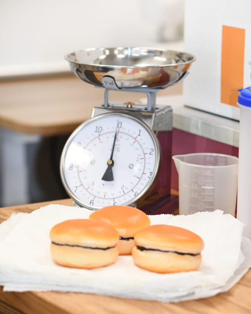 A scale with three hamburger buns on it