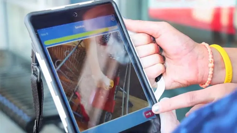 Person scanning a product using a tablet at a supermarket checkout.