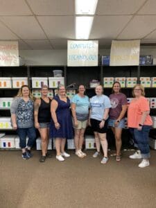 A group of people standing in front of shelves.
