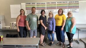 A group of people standing in front of a wall.