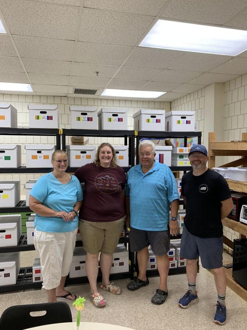 A group of people standing in front of boxes.