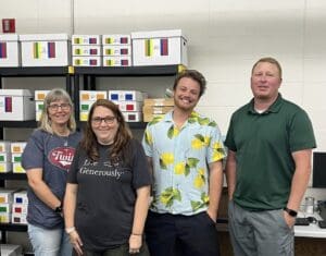 A group of people standing in front of boxes.