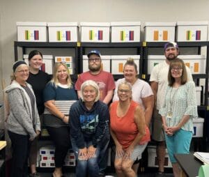 A group of people standing in front of boxes.