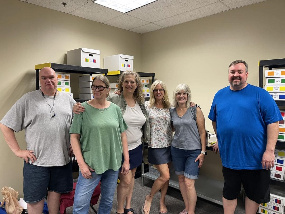 A group of people standing in front of boxes.