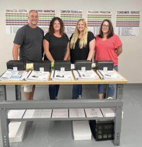 A group of people standing around a table.