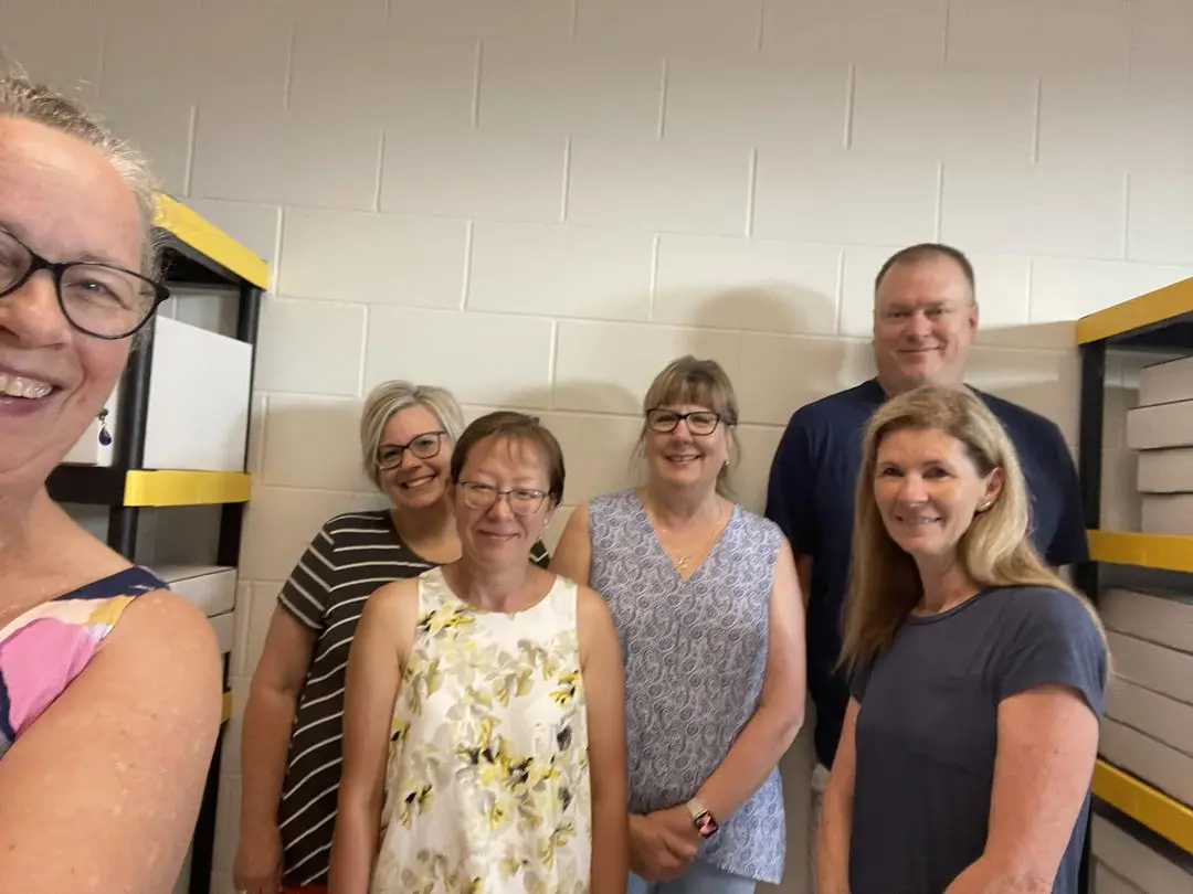 A group of people standing in front of some shelves.