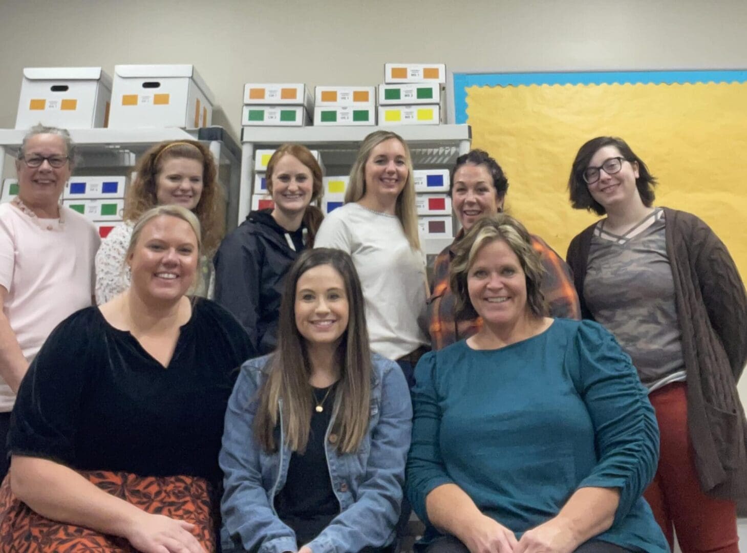 A group of women sitting in front of boxes.