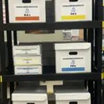 A shelf with several boxes of papers on it.