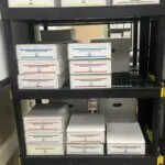 A shelf with many boxes of papers on it