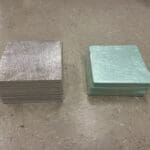 A couple of square pieces of metal sitting on top of a floor.