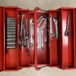 A red toolbox with many different tools inside of it.