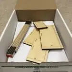 A box of cardboard with some wood pieces in it