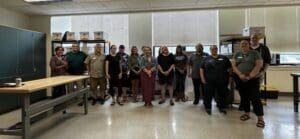 A group of people standing in front of windows.