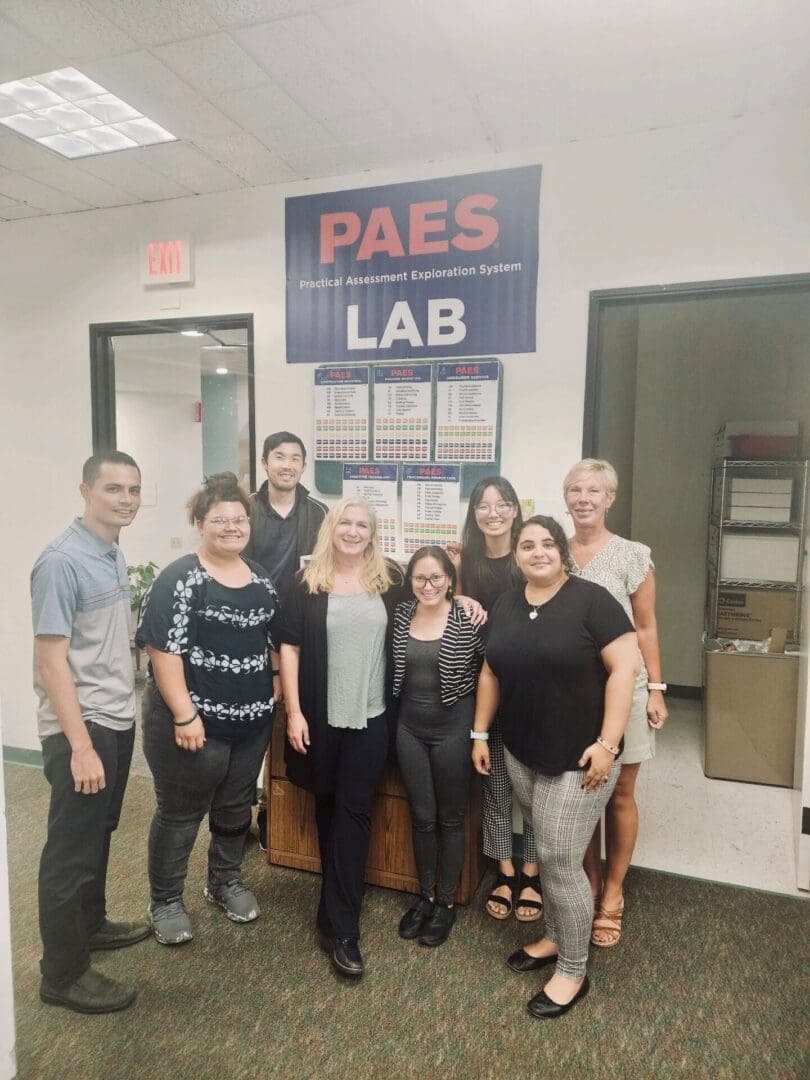 A group of people standing in front of a sign.