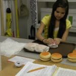 Student wrapping hamburgers in work lab setting