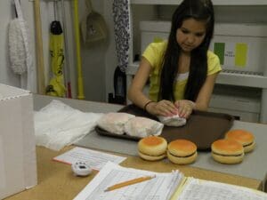 Student wrapping hamburgers in work lab setting