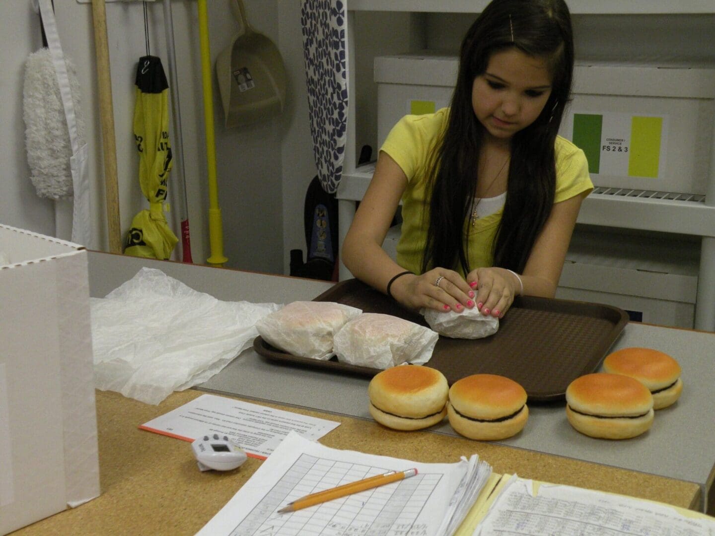 Student wrapping hamburgers in work lab setting