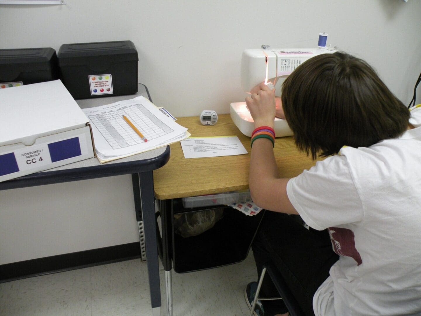 Student working at a sewing machine in work lab setting.
